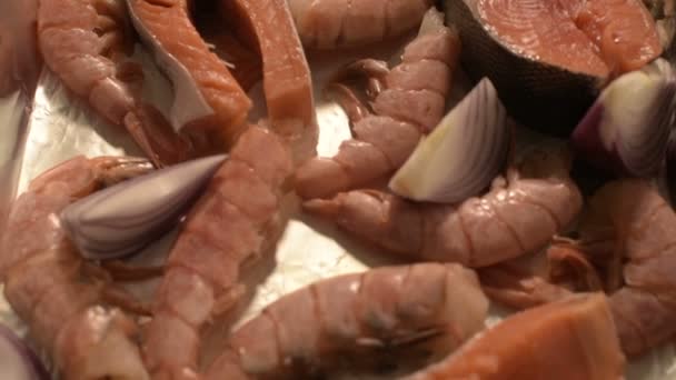 Gros plan sur les fruits de mer sur protvine. Saumon cru avec crevettes et oignons crus à rôtir. Profondeur de champ faible. vue de dessus — Video