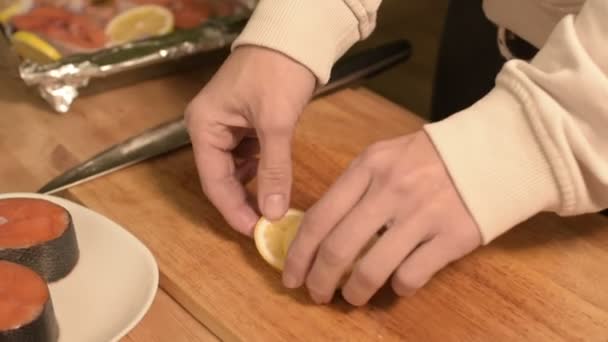 O close-up das mãos da menina na cozinha de casa expõe canções de limão fatiadas em um prato em uma bandeja. Cozinha caseira saudável — Vídeo de Stock