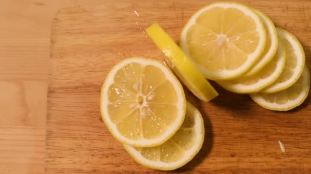 Closeup of sliced lemon sausages on a wooden cutting board. Lemon application in home kitchen — Stock Video