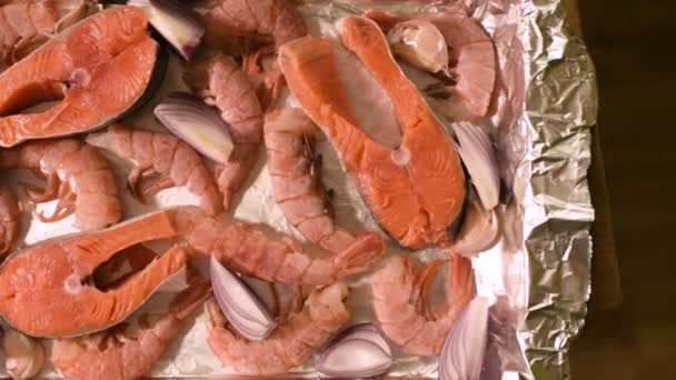 Close-up zeevruchten op protvine. Rauwe zalm met garnalen en rauwe uien te roosteren. Ondiepe scherptediepte. bovenaanzicht — Stockvideo