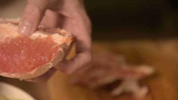 Detailní záběr na rukou a dívka v domácí kuchyni čistí a kotlety grapefruitu pro vegetariánský salát. Zdravé domácí vaření — Stock video