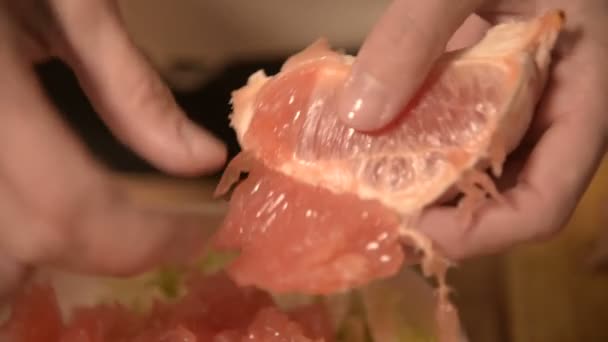 Close-up de mãos uma menina na cozinha casa limpa e costeletas toranja para uma salada vegetariana. Cozinha caseira saudável — Vídeo de Stock