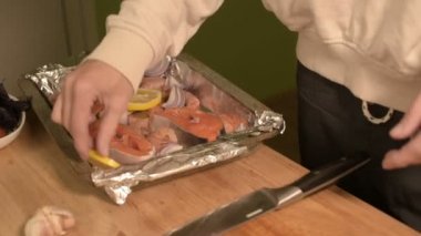 Kız ev mutfakta elinde closeup dilimlenmiş limon şarkıları bir tabak bir tepsi üzerinde düzenleme. Sağlıklı ev yemekleri