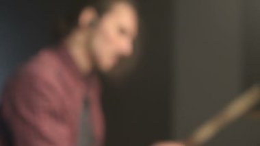 Uzun saçlı davulcular davul kiti karanlık bir odada bir siyah arka plan üzerinde oynamak. Rock müzisyeni. Statik plan. Geniş açı