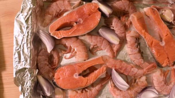 Mořské plody detail na protvine. Syrového lososa s krevetami a syrové cibule pečená. Malá hloubka ostrosti. pohled shora — Stock video