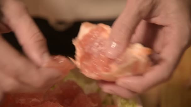 Закрытие рук девушка на домашней кухне убирает и отбивает грейпфрут для вегетарианского салата. Здоровое домашнее питание — стоковое видео