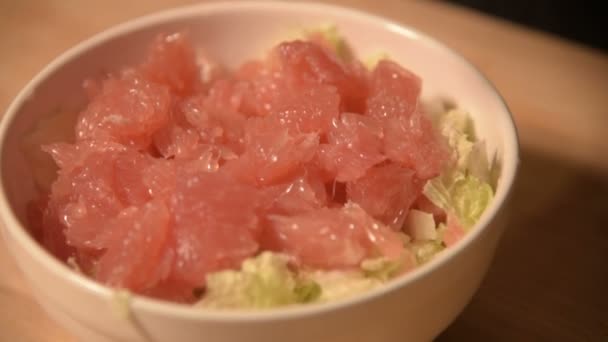 El primer plano de las manos de una chica en la cocina de casa limpia y corta pomelo para una ensalada vegetariana. Cocina casera saludable — Vídeos de Stock