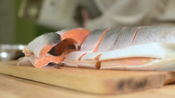 Primer plano lonchas de salmón rebanadas de pescado dietético rojo en una tabla de cortar de madera. Cocina casera. Alimento saludable — Vídeos de Stock