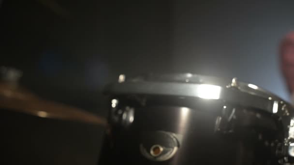 Långhåriga trummisar Spela trumset i ett mörkt rum på en svart bakgrund. Vaggamusiker. Statisk plan. Vidvinkel — Stockvideo