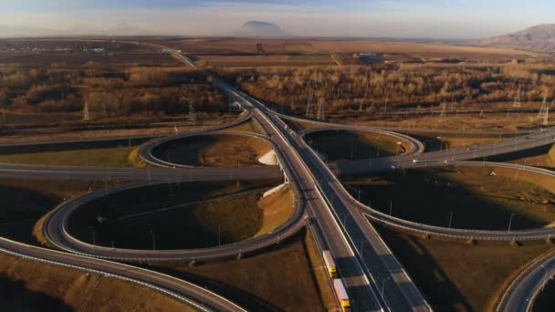 Vista aérea. Auto-estrada e viaduto com carros e caminhões. A junção rodoviária é uma junção rodoviária de dois níveis fora da cidade. Vista de cima — Vídeo de Stock