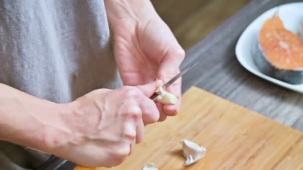 Nahaufnahme von weiblichen Händen in der heimischen Küche reinigen Knoblauch von der Schale. geringe Schärfentiefe — Stockvideo