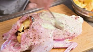 Erkek Close-up hazırlanıyor ördek ya da kaz pişirme için eller. Mayonezli havuç soyunma beyaz. Elma ile Noel yemeği ördek kaz.