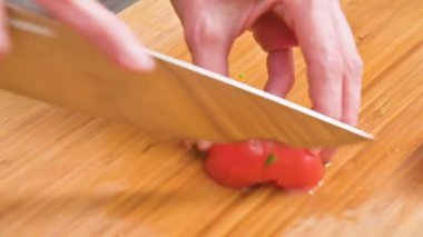 Close-up eller bir bıçak ile kesme domates salatası ahşap kesme tahtası üzerinde yapmak için vardır. Ev mutfak. Sağlıklı gıda