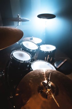 Yakın çekim davul spot zemin karşı karanlık bir odada ayarlayın. Rock veya jazz Davul çalarken atmosferik arka plan sembolü. Soğuk bir arka plan üzerine bakır plakalar