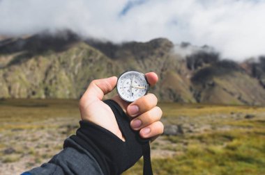 Bakış açısı vurdu. Bir birinci şahıs bakış bir el tutar kayalıklarla hills, epik bir yatay ve bir mavi gökyüzü bulutlu arka planı pusula mans