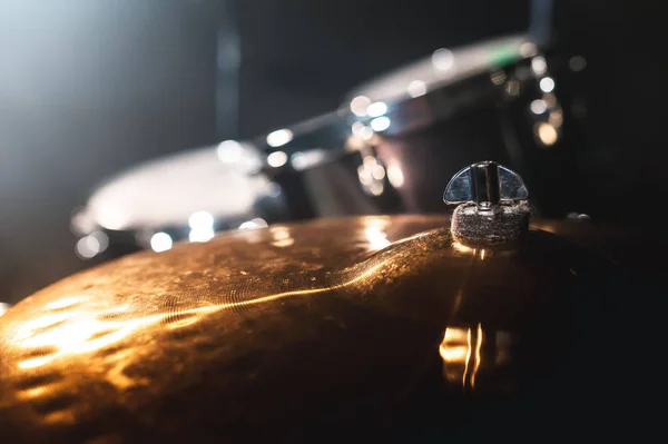 Primo piano Drum ambientato in una stanza buia sullo sfondo dei riflettori. Sfondo atmosferico simbolo di suonare la batteria rock o jazz. Lastre di rame su fondo freddo — Foto Stock