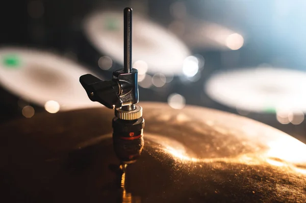 Nahaufnahme eines Schlagzeugs in einem dunklen Raum vor dem Hintergrund des Scheinwerferlichts. atmosphärisches Hintergrundsymbol für das Spielen von Rock- oder Jazz-Drums. Kupferplatten auf kaltem Hintergrund — Stockfoto