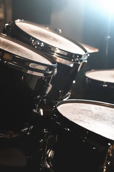Vista de perto de um tambor montado em um estúdio escuro. Barris de tambor preto com acabamento cromado. O conceito de performances ao vivo — Fotografia de Stock