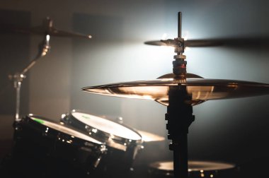 Yakın çekim davul spot zemin karşı karanlık bir odada ayarlayın. Rock veya jazz Davul çalarken atmosferik arka plan sembolü. Soğuk bir arka plan üzerine bakır plakalar.