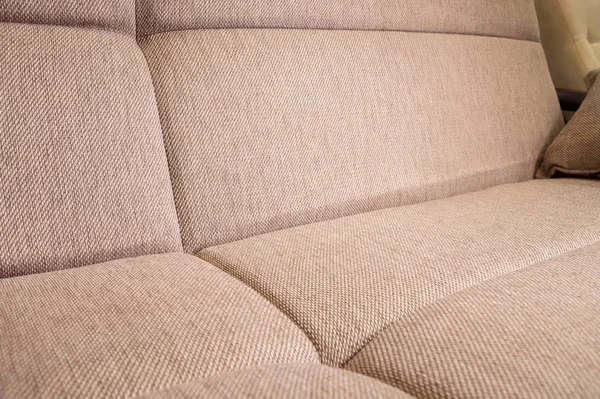 Gros plan d'un fragment d'un canapé textile beige cher dans la chambre — Photo
