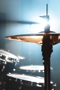 Yakın çekim davul spot zemin karşı karanlık bir odada ayarlayın. Rock veya jazz Davul çalarken atmosferik arka plan sembolü. Soğuk bir arka plan üzerine bakır plakalar.