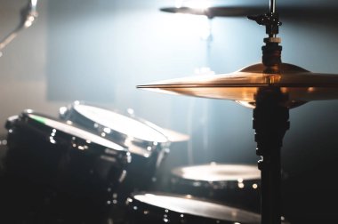 Yakın çekim davul spot zemin karşı karanlık bir odada ayarlayın. Rock veya jazz Davul çalarken atmosferik arka plan sembolü. Soğuk bir arka plan üzerine bakır plakalar
