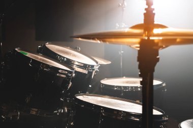 Yakın çekim davul spot zemin karşı karanlık bir odada ayarlayın. Rock veya jazz Davul çalarken atmosferik arka plan sembolü. Soğuk bir arka plan üzerine bakır plakalar