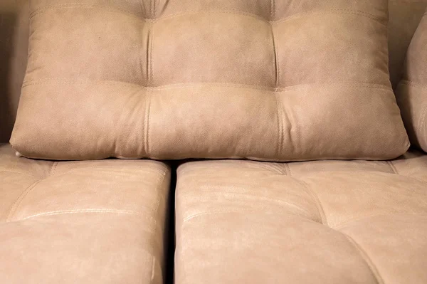 Un primo piano di un frammento di un costoso divano tessile beige nella stanza — Foto Stock
