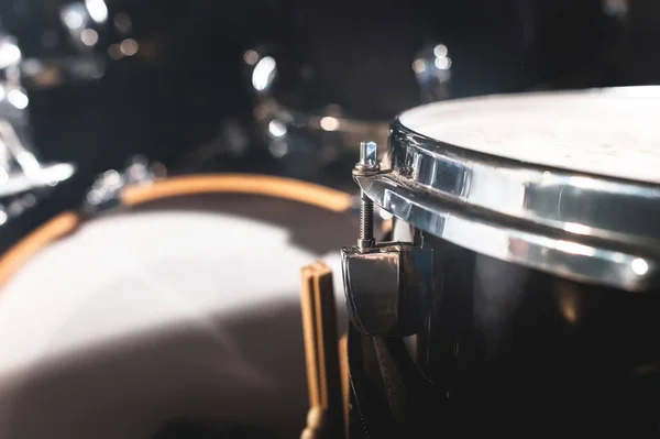 Nahaufnahme eines Schlagzeugs und Drumsticks in einem dunklen Studio. schwarze Trommelfässer mit Chrombesatz. das Konzept der Live-Auftritte — Stockfoto