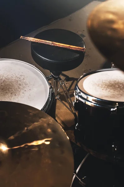 Vista de perto de um conjunto de tambores e baquetas em um estúdio escuro. Barris de tambor preto com acabamento cromado. O conceito de performances ao vivo — Fotografia de Stock