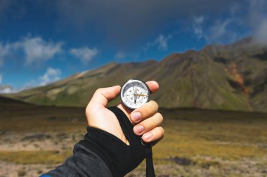 Bakış açısı vurdu. Bir birinci şahıs bakış bir el tutar kayalıklarla hills, epik bir yatay ve bir mavi gökyüzü bulutlu arka planı pusula mans
