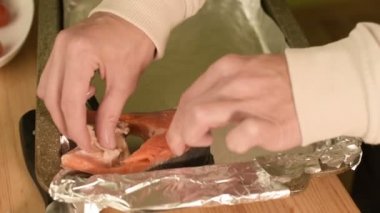 Deniz ürünleri kavurma için bir fırın tepsisindeki yaymak eller Close-up