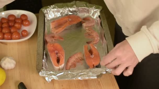 Gros plan des mains féminines étalées sur une plaque à pâtisserie pour rôtir les fruits de mer — Video