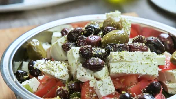 Primo piano dell'aggiunta manuale di condimento a un'insalata di verdure greca. Cucina vegetariana. Cibo sano — Video Stock