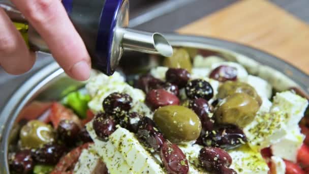 Closeup of a female hand watering fresh vegan greek salad olive oil. Natural food healthy lifestyle — Stock Video