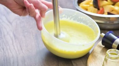 Plastik bir kabın içinde bir blender ile ev yapımı mayonez kırbaçlanan yakın çekim