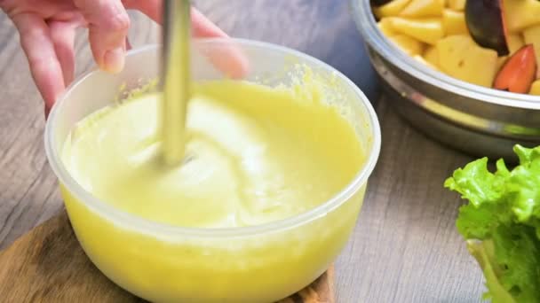 Close-up whipping homemade mayonnaise with a blender in a plastic bowl — Stock Video