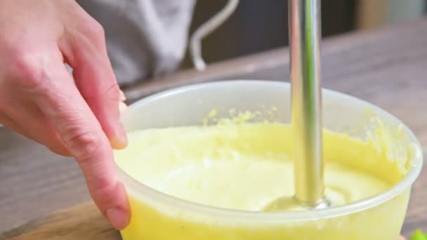 Nahaufnahme Schlagsahne hausgemachte Mayonnaise mit dem Mixer in einer Plastikschüssel — Stockvideo