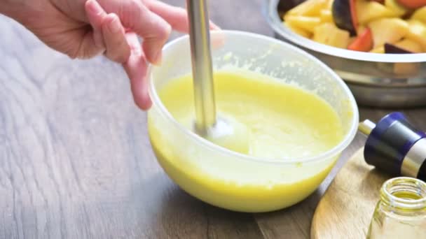 Close-up zweepslagen zelfgemaakte mayonaise met een mixer in een plastic kom — Stockvideo