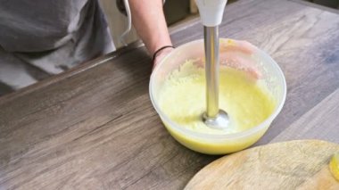Plastik bir kabın içinde bir blender ile ev yapımı mayonez kırbaçlanan yakın çekim