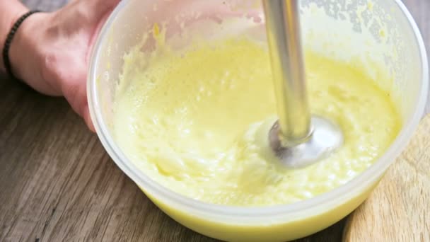 Close-up whipping homemade mayonnaise with a blender in a plastic bowl — Stock Video