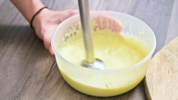 Nahaufnahme Schlagsahne hausgemachte Mayonnaise mit dem Mixer in einer Plastikschüssel — Stockvideo