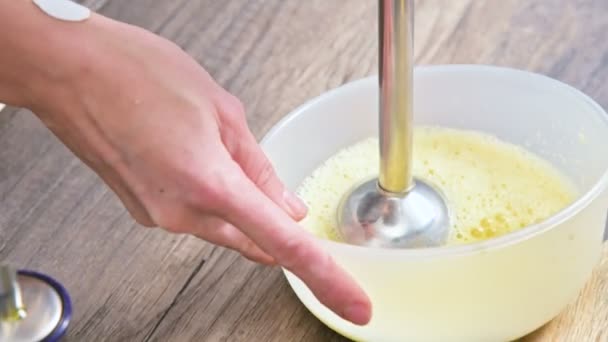 Zbliżenie, biczowanie domowej roboty majonez mixerem w plastikowej miski — Wideo stockowe