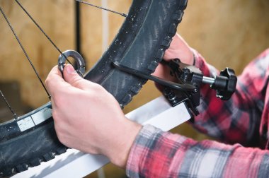 Mens el jant dayak ortadan kaldırarak tekerlek tekerlek teli sıkma atölye bir stand üzerinde özel bir anahtar ile yakın çekim.