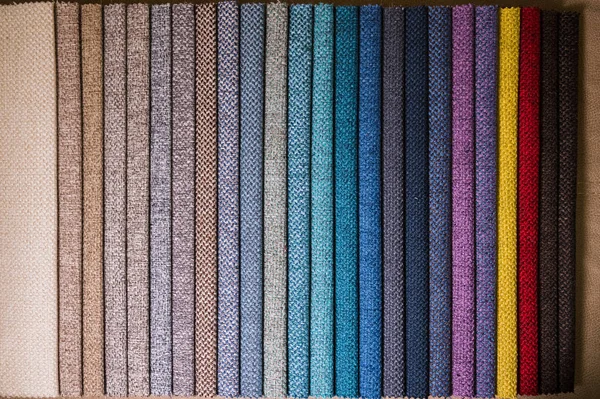 Colorful and bright fabric samples of furniture and clothing upholstery. Close-up of a palette of textile abstract stripes of different colors