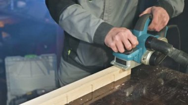 Bir elektrikli uçak eve bir atölyede çalışan bir marangoz El Close-up. Ahşap parçaları bitirme