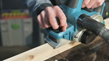 Bir elektrikli uçak eve bir atölyede çalışan bir marangoz El Close-up. Ahşap parçaları bitirme