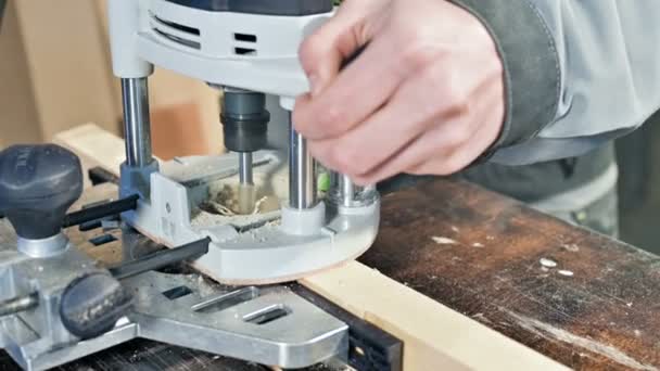 Close-up de uma mão carpinteiros trabalhando com um cortador elétrico manual em uma oficina em casa. Acabamento de peças de madeira — Vídeo de Stock