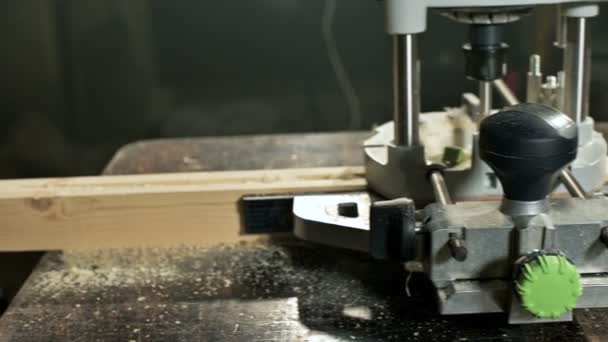 Nahaufnahme einer Tischlerhand, die in einer heimischen Werkstatt mit einem elektrischen Handfräser arbeitet. Veredelung von Holzteilen — Stockvideo