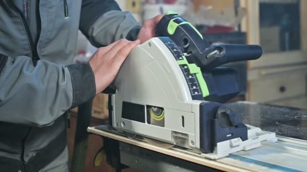 Nahaufnahme eines Tischlers, der in einer heimischen Werkstatt mit einer Handkreissäge arbeitet. Veredelung von Holzteilen — Stockvideo